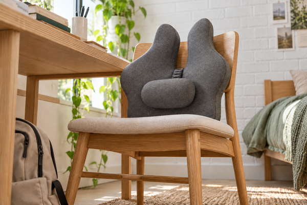 Floor-level view of the grey back support cushion on a study chair beside a desk